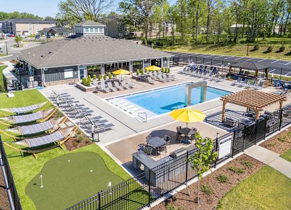 A large outdoor pool area with sun loungers and a putting green.