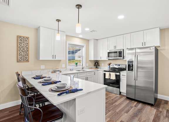 a kitchen with white cabinets and stainless steel appliances