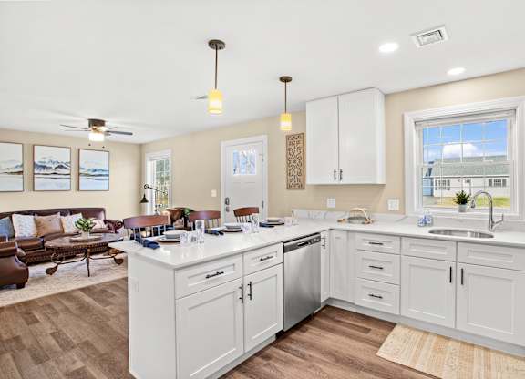 a kitchen with white cabinets and a living room with a couch
