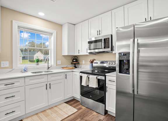 a kitchen with stainless steel appliances and white cabinets