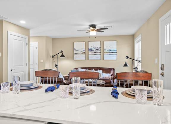 a living room with a white counter and a dining table