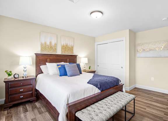 a bedroom with a large bed and a bench