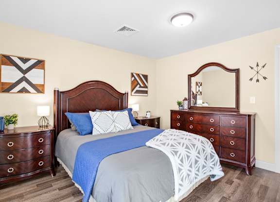a bedroom with a bed and two dressers