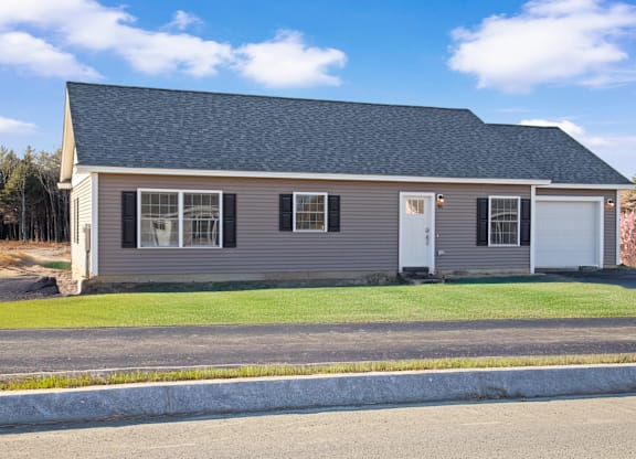 the front of a house with a lawn and a white door