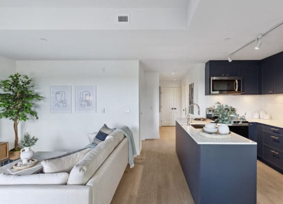 a kitchen and living room with a white couch and a counter
