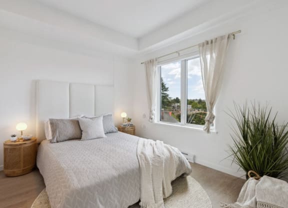 a white bedroom with a bed and a window