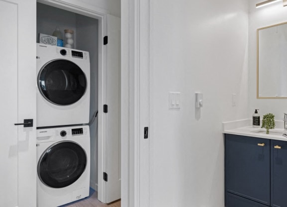 a small laundry room with a washing machine and a sink