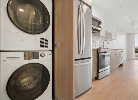 A modern kitchen with a washing machine and oven.