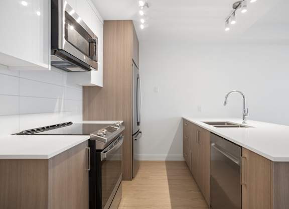 A modern kitchen with wooden cabinets and stainless steel appliances.