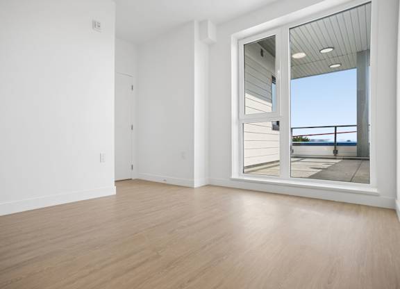A room with a sliding glass door leading to a balcony.