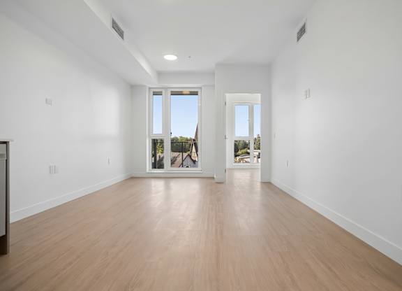 A large empty room with wooden floors and white walls.