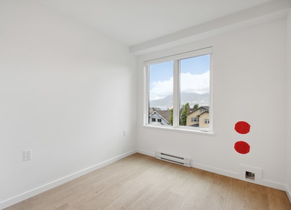 an empty room with white walls and a window