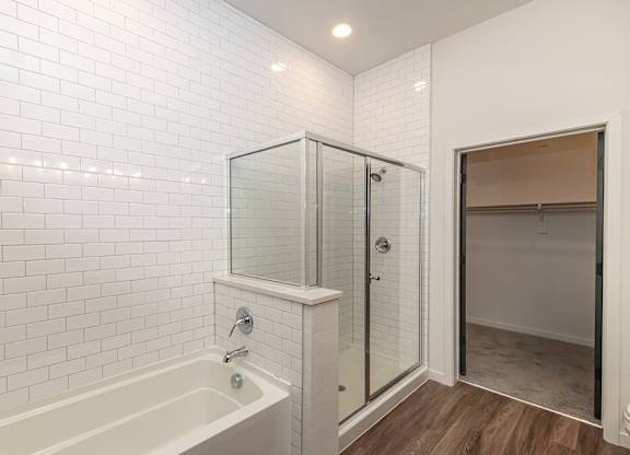 A white tiled bathroom with a glass shower stall  at Bridges at Flatiron, Broomfield, 80021