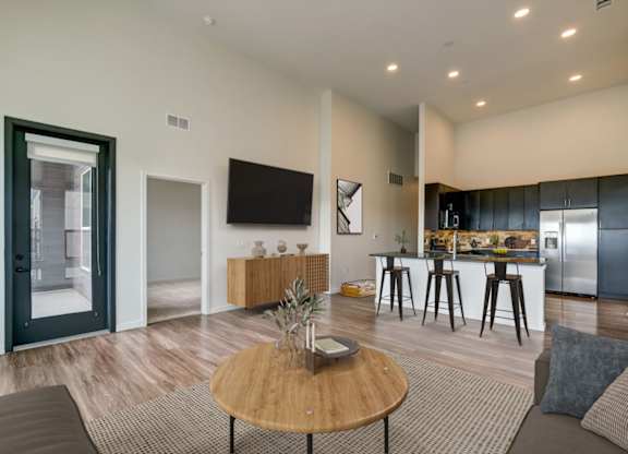 A modern living room with a wooden coffee table and a flat screen TV mounted on the wall.