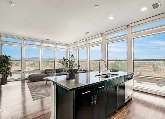 A modern kitchen with a large island and a view of the mountains.