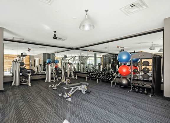 A gym with a variety of equipment including weights and exercise balls  at Bridges at Flatiron, Broomfield, 80021