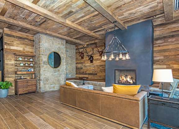 A cozy living room with a fireplace and a couch  at Bridges at Flatiron, Broomfield, 80021