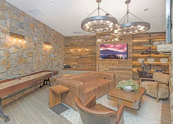 A living room with a stone wall and a wooden bench  at Bridges at Flatiron, Broomfield, 80021