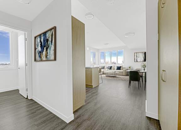 A living room with a grey floor and a painting on the wall.