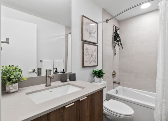 a bathroom with a toilet sink and bathtub in a 555 waverly unit