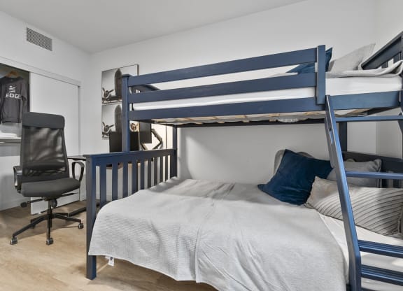 a bedroom with a bunk bed and a desk