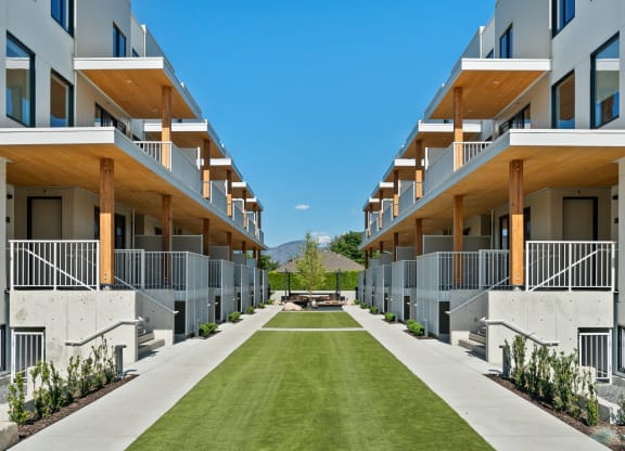 a grassy area in the middle of a row of apartment buildings