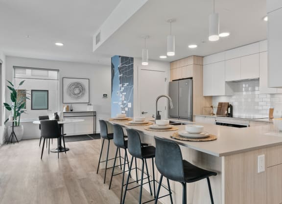 a kitchen with an island and stools in a 555 waverly unit