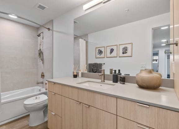 a bathroom with a toilet sink and bathtub in a 555 waverly unit