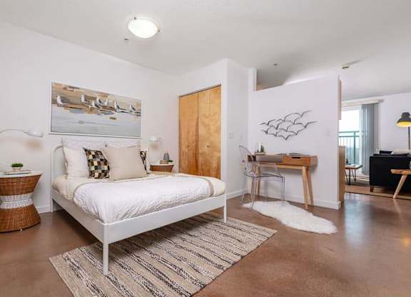 a bedroom with a white bed and a desk