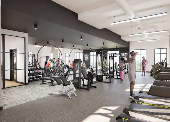 A man is walking through a gym with treadmills and other exercise equipment.