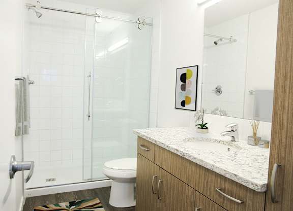 A bathroom with a toilet, sink, and shower.