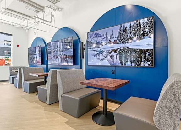 A room with a blue wall and a wooden table with chairs.