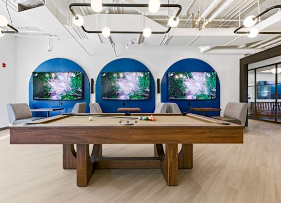 A pool table with a blue screen behind it.
