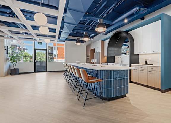 A modern kitchen with a long island and chairs.