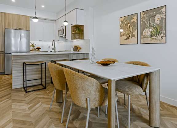 A modern kitchen with a dining table and chairs.