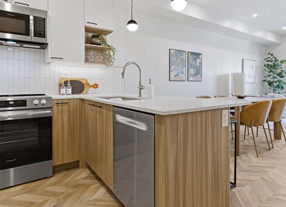 A modern kitchen with wooden flooring and a large island.