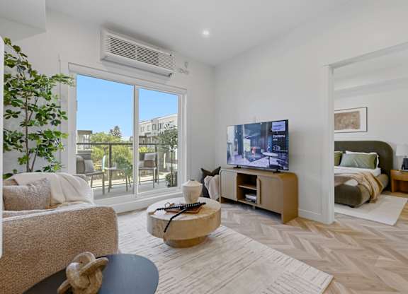 A living room with a flat screen TV and a large window.