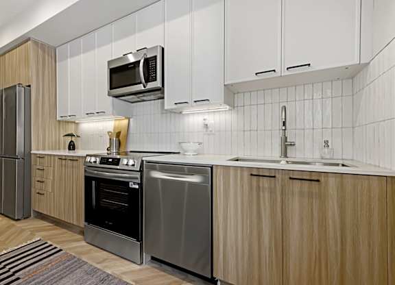 A modern kitchen with wooden cabinets and stainless steel appliances.