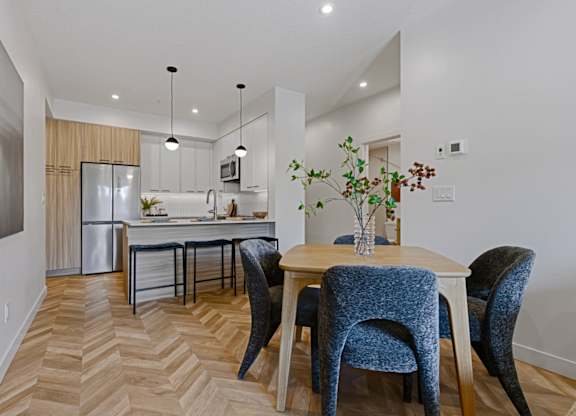 A kitchen with a dining table and chairs.