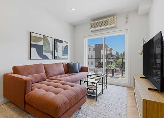 A living room with a brown couch and a television.