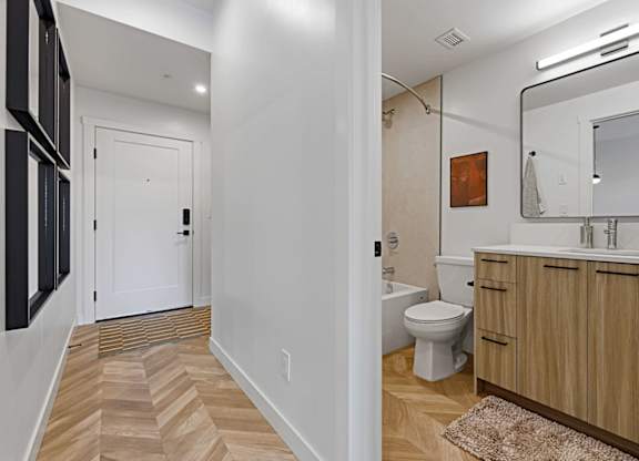A bathroom with a toilet, sink, and mirror.