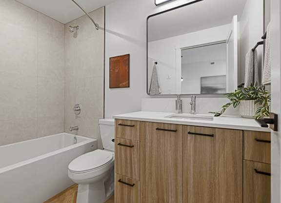 A bathroom with a white toilet, a white sink, and a white bathtub.