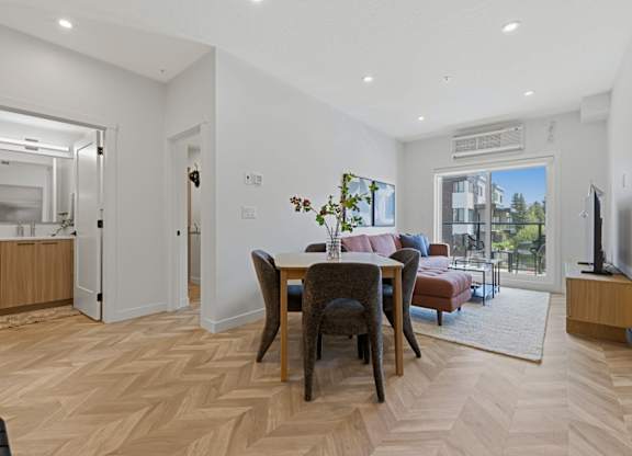 A living room with a dining table and chairs.