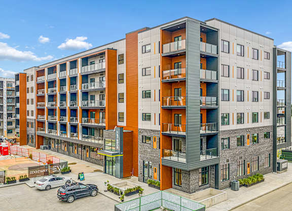 A modern apartment building with orange and grey accents.