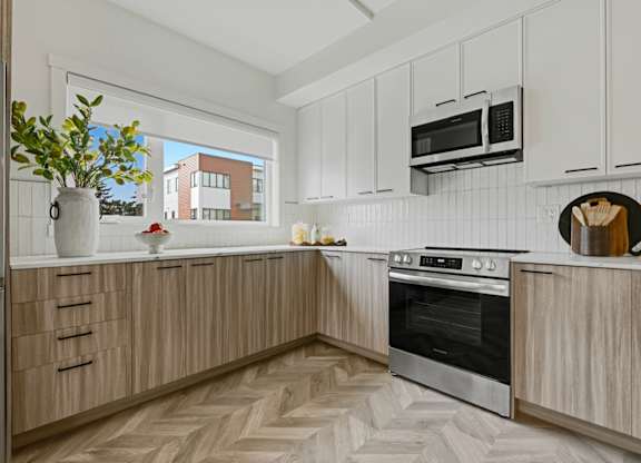 A kitchen with wooden cabinets and a black oven.