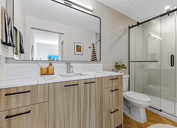 A bathroom with a white toilet, sink, and wooden cabinets.