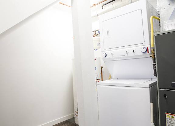 A white oven is in a room with white walls.