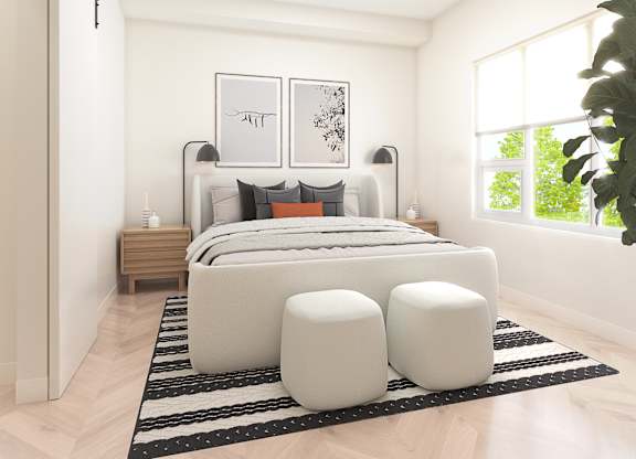 A modern bedroom with a large bed, two nightstands, and a large window.