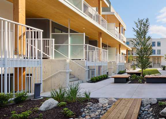A modern apartment complex with balconies and a landscaped courtyard.