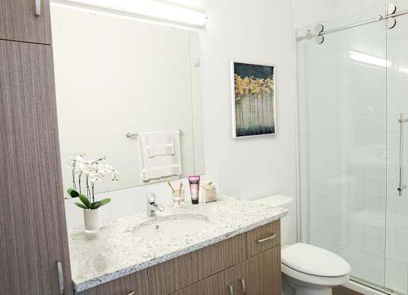 A bathroom with a white sink and a white toilet.